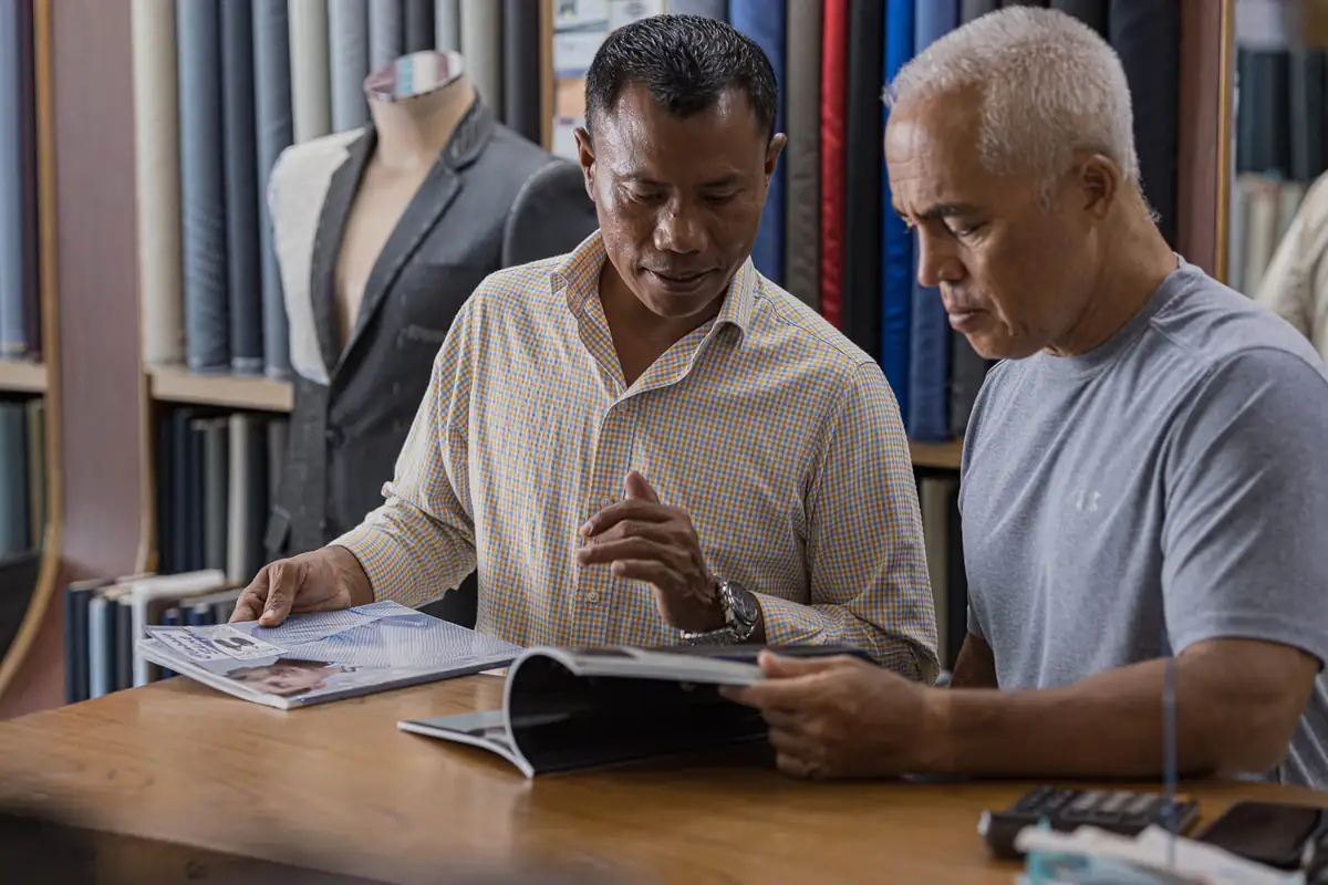 Professional consultation at New David Jone Fashion - best custom tailor in Patong helping client choose fabric and style for bespoke suit in Phuket Thailand