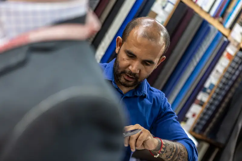 Patong tailor showing tropical-weight suiting to a customer (Ref 9661)