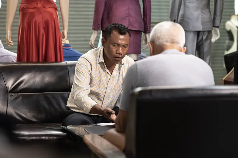 Senior tailor with fabric bolts, David Jone Fashion workshop, Patong (Ref 6288)